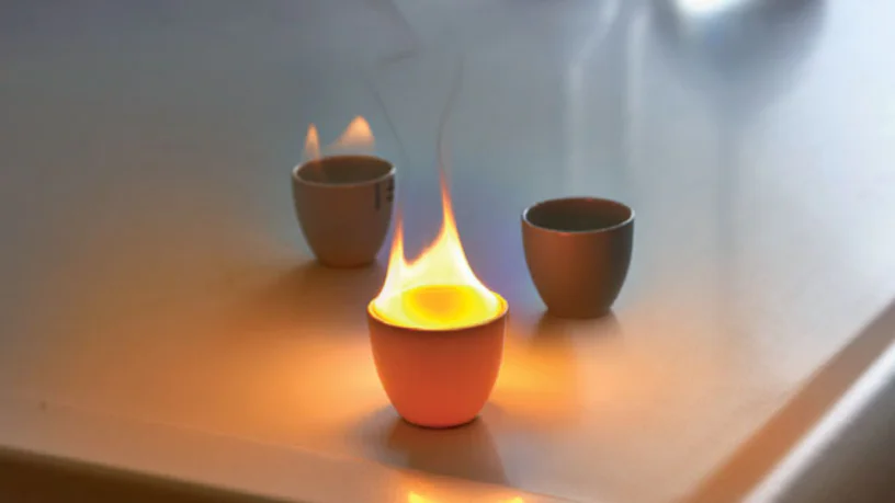 Drei winzige feuerfeste Becher aus dem Labor, zwei von ihnen brennen.
