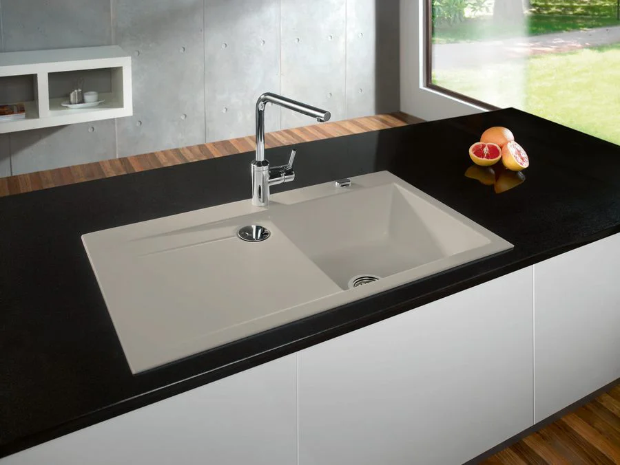 Beige Keramikspüle in schwarzer Arbeitsplatte