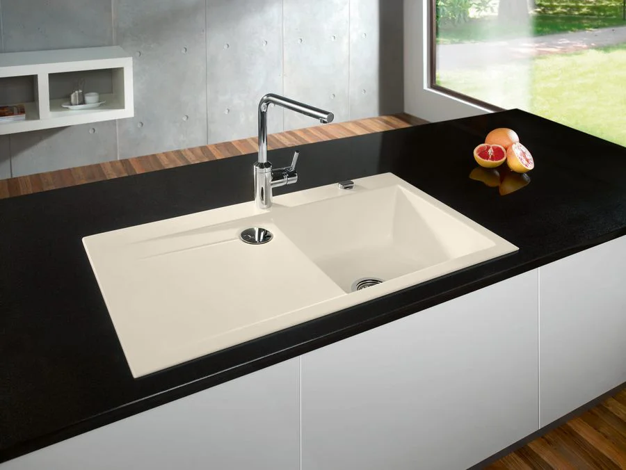 Beige/ Weisse Keramikspüle in schwarzer Arbeitsplatte