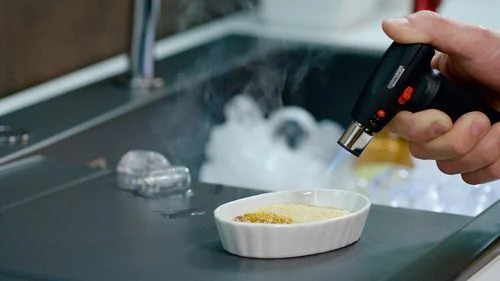 Creme brulee wird flambiert