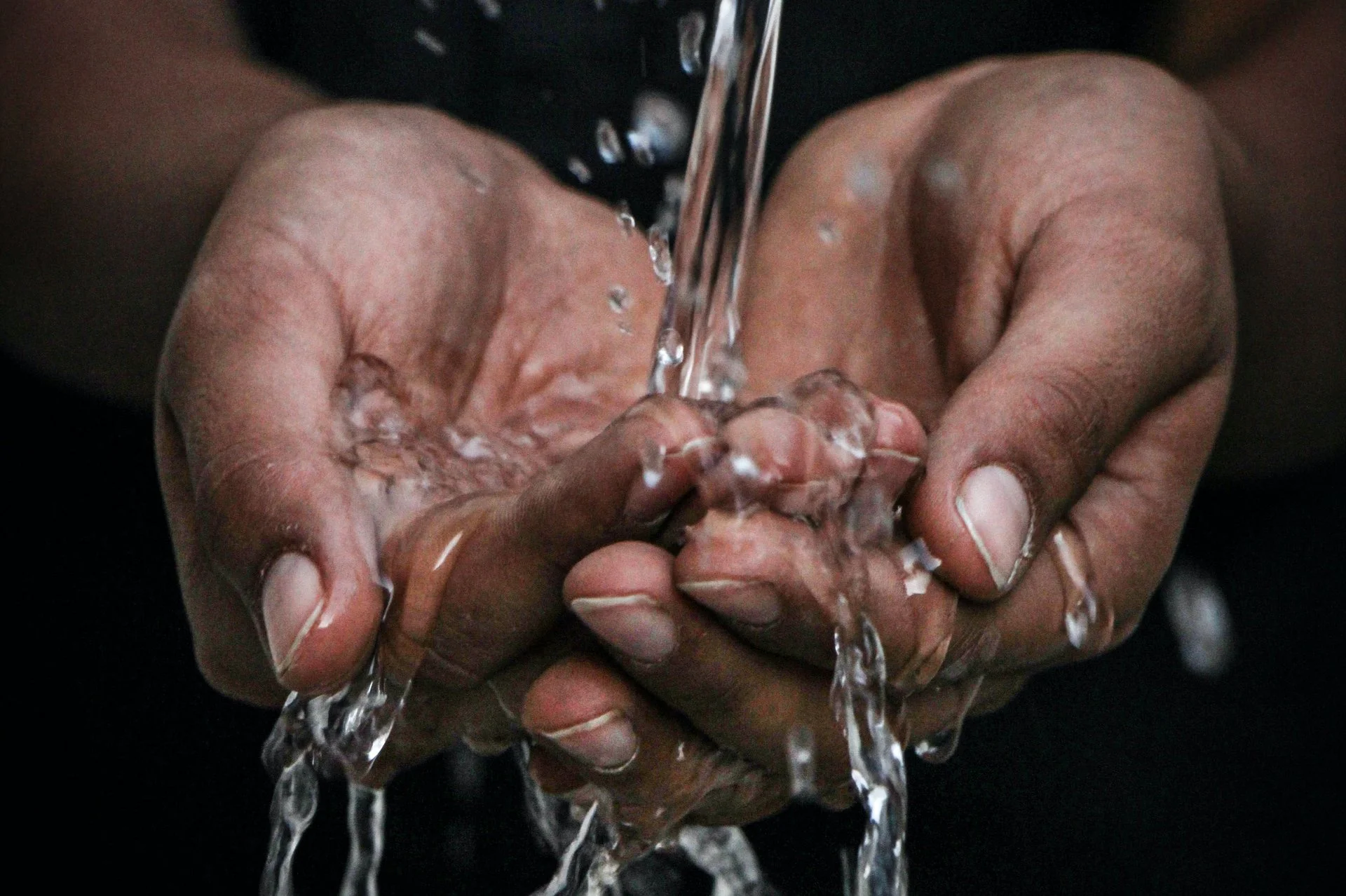 Zwei Hände, über die Wasser läuft